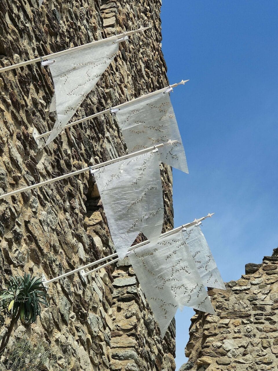 aux disparues, 2024, porte drapeau métal, bâche, agraffes parisiennes, 1m50 x 30 cm